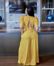 Yellow backless jumpsuit with puff sleeves and open V-back tie detail