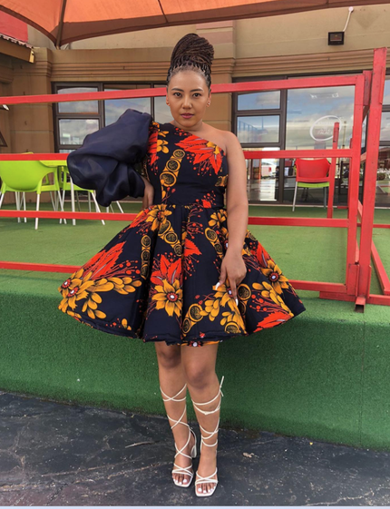 One-shoulder puff sleeve dress with navy floral African print, fitted bodice and flared skirt
