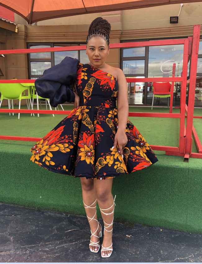 One-shoulder puff sleeve dress with navy floral African print, fitted bodice and flared skirt