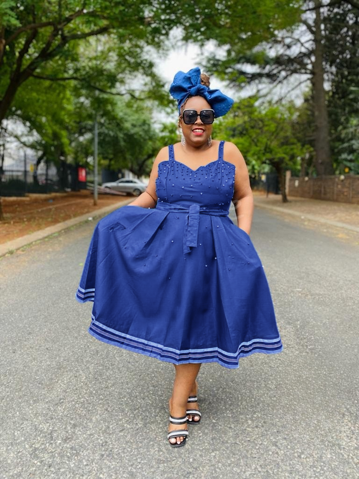 Blue flared dress with adjustable spaghetti straps, V-neck bodice, striped hem