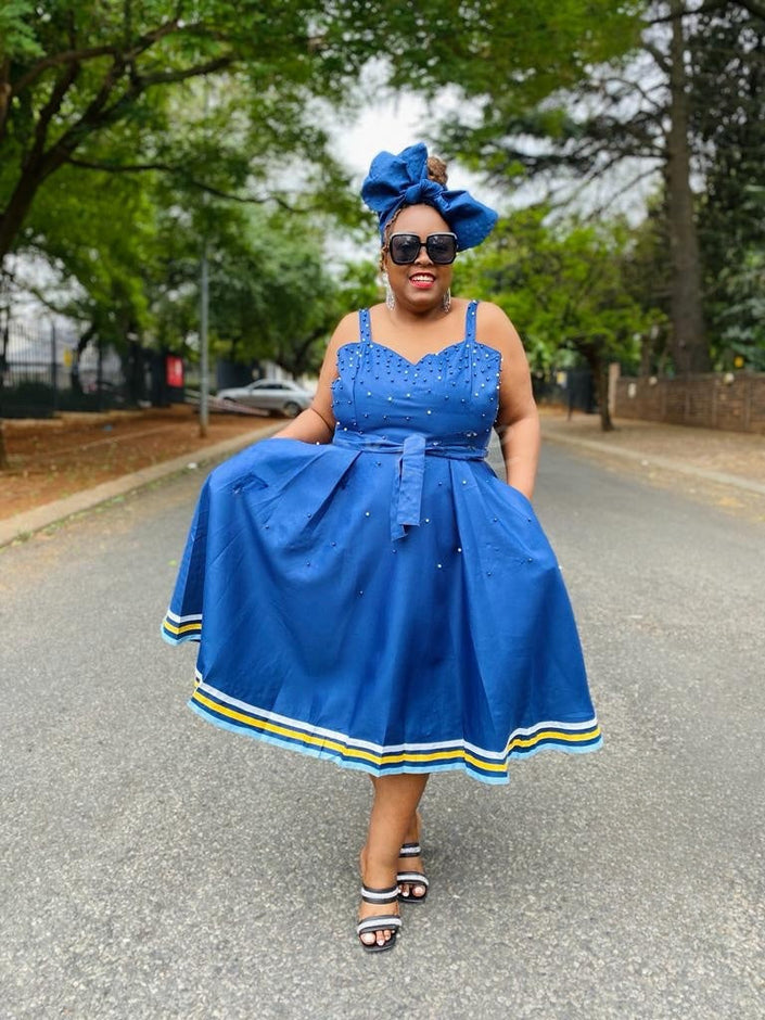 Navy-blue flared dress with adjustable straps, fitted waist and striped hem