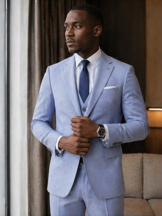 Light blue three-piece slim-fit suit with navy tie, vest, and matching trousers
