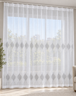 White sheer curtain with repeating gray embroidered leaf motifs across the center and hem