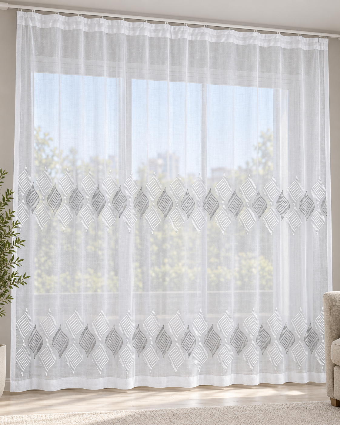 White sheer curtain with repeating gray embroidered leaf motifs across the center and hem