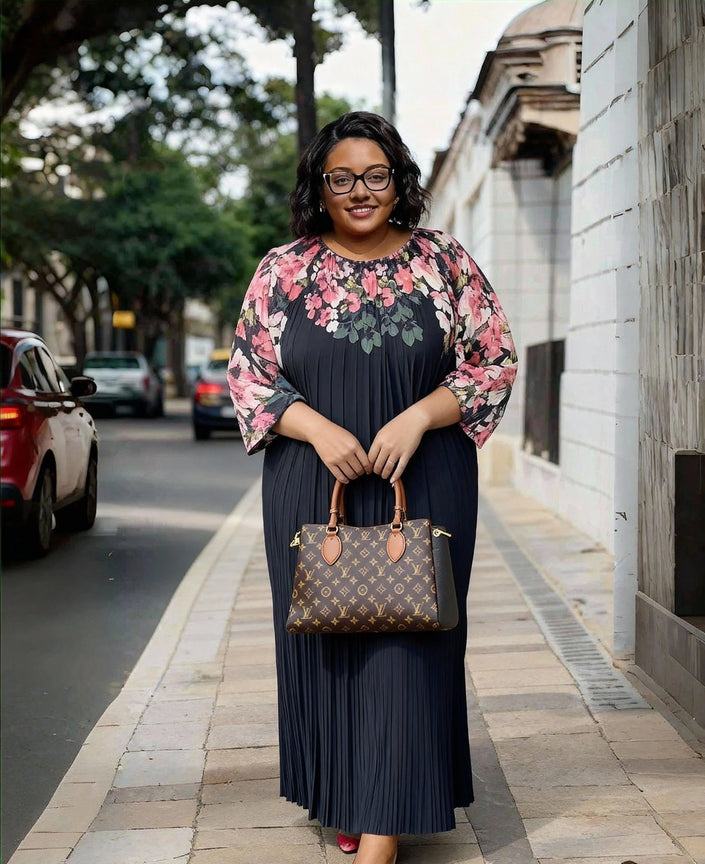 Navy pleated maxi dress with round neckline, floral puff sleeves, and long sleeves.