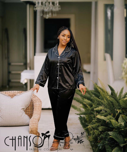 Black satin pajama set with white piping, collared button top and tapered pants