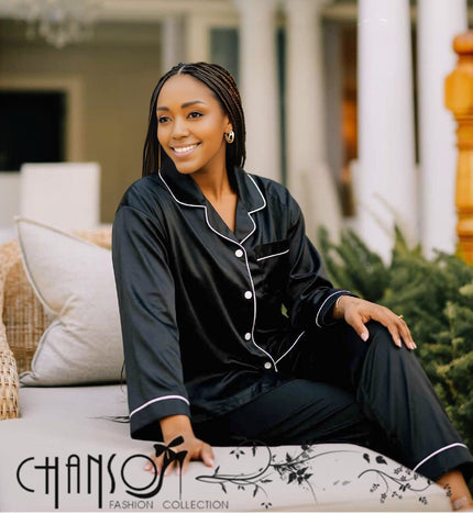 Black satin pajama set with white piping, button-front top and long pants