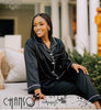 Black satin pajama set with white piping, button-front top and long pants