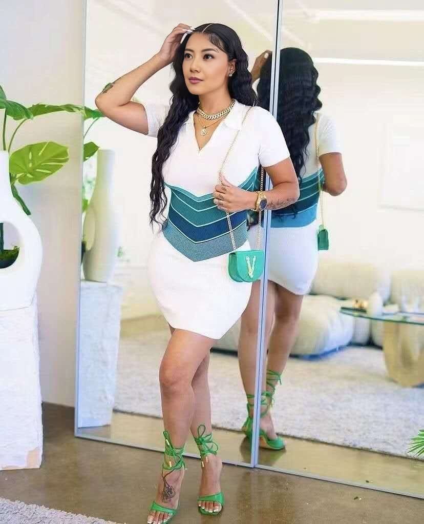 White knitted cinch dress with teal geometric waist stripes, short sleeves and V-neck.