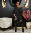 Black off-shoulder knit dress with loose fit, three-quarter sleeves, relaxed neckline