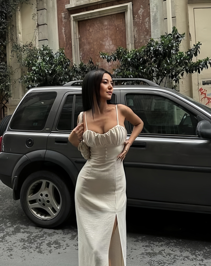 Cream midi dress with ruched bodice, spaghetti straps, and front slit