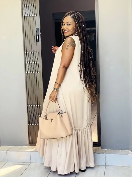 Beige sleeveless maxi dress with ruffle hem and tiered gathered skirt.
