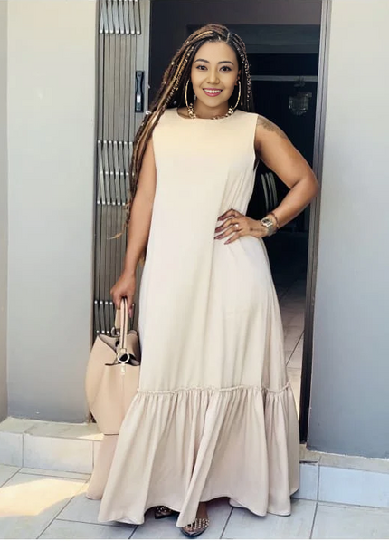 Beige sleeveless maxi dress with ruffle hem and gathered lower tier.
