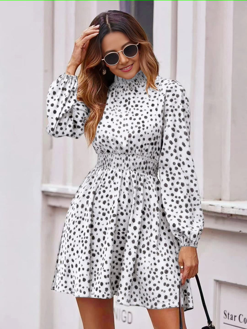 White dotted mini dress with puff sleeves, high neckline, and gathered skirt