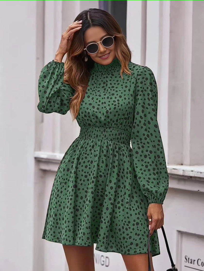 Dark-green dotted mini dress with puff sleeves, high neckline, and elastic waist