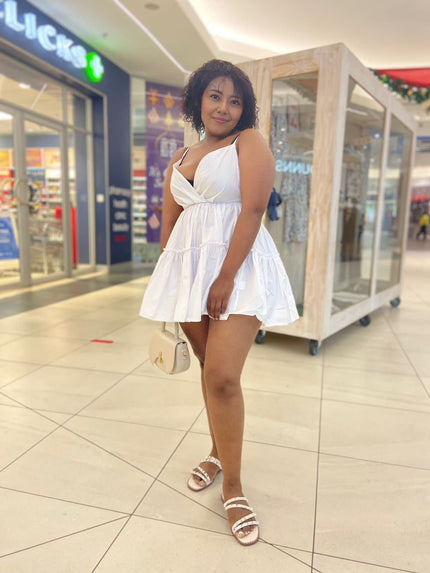 White ruffle V-neck mini dress with adjustable spaghetti straps, tiered skirt