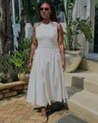White sleeveless midi dress with side ruching and gathered skirt