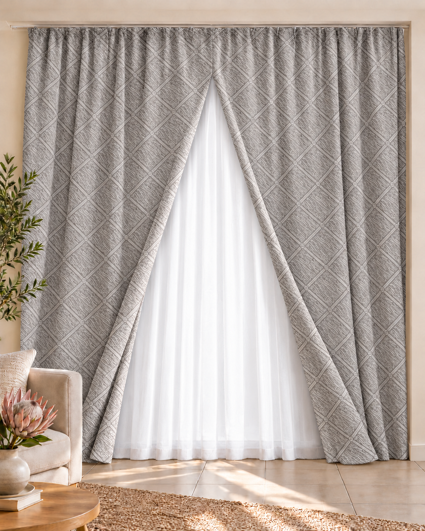 Gray geometric jacquard curtain set framing a sheer white panel