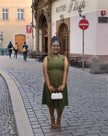 Army-green sleeveless midi utility dress with front pockets and fitted waistband