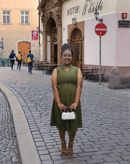 Army-green sleeveless midi utility dress with front pockets and fitted waistband