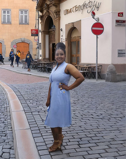 Sky-blue sleeveless midi utility dress with front pockets and fitted waistband