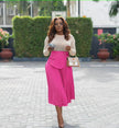 Pleated A-line midi skirt with stretch waistband and front drape panel in hot pink