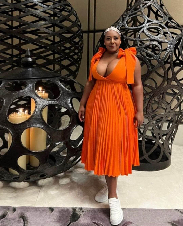 Orange-red pleated midi dress with V-neckline and gathered bodice, sleeveless