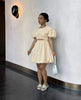 Tan mini dress with puff sleeves and cut-out waist