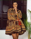 Printed puff-sleeve dress with short skirt, dark fabric and ornate gold patterns