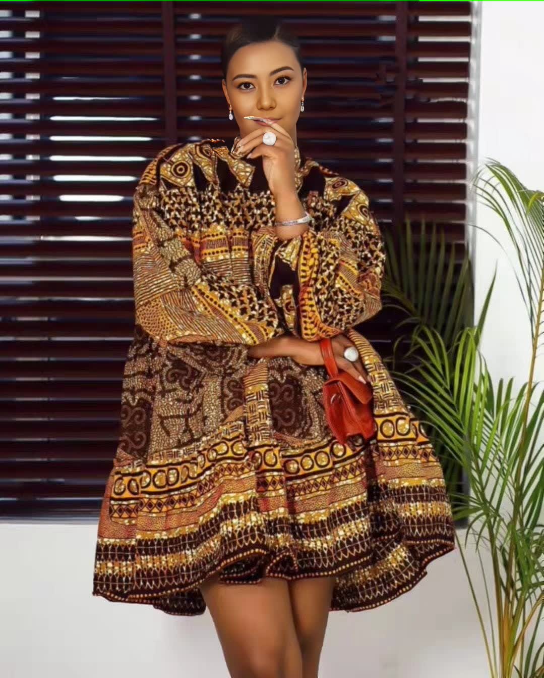 Printed puff-sleeve dress with short skirt, dark fabric and ornate gold patterns