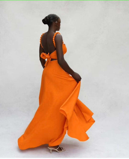 Orange maxi dress with square neckline, pom-pom straps, bow detail at back