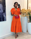 Orange-red tiered midi dress with flutter sleeves, V-neck, and fitted waist