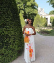 Strapless maxi dress with pleated bodice and bold orange floral print, sleeveless