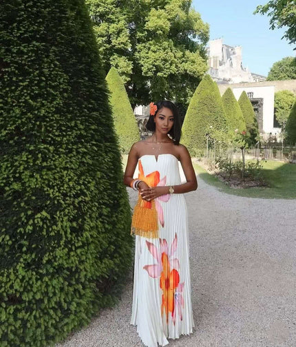 Strapless maxi dress with pleated bodice and bold orange floral print, sleeveless