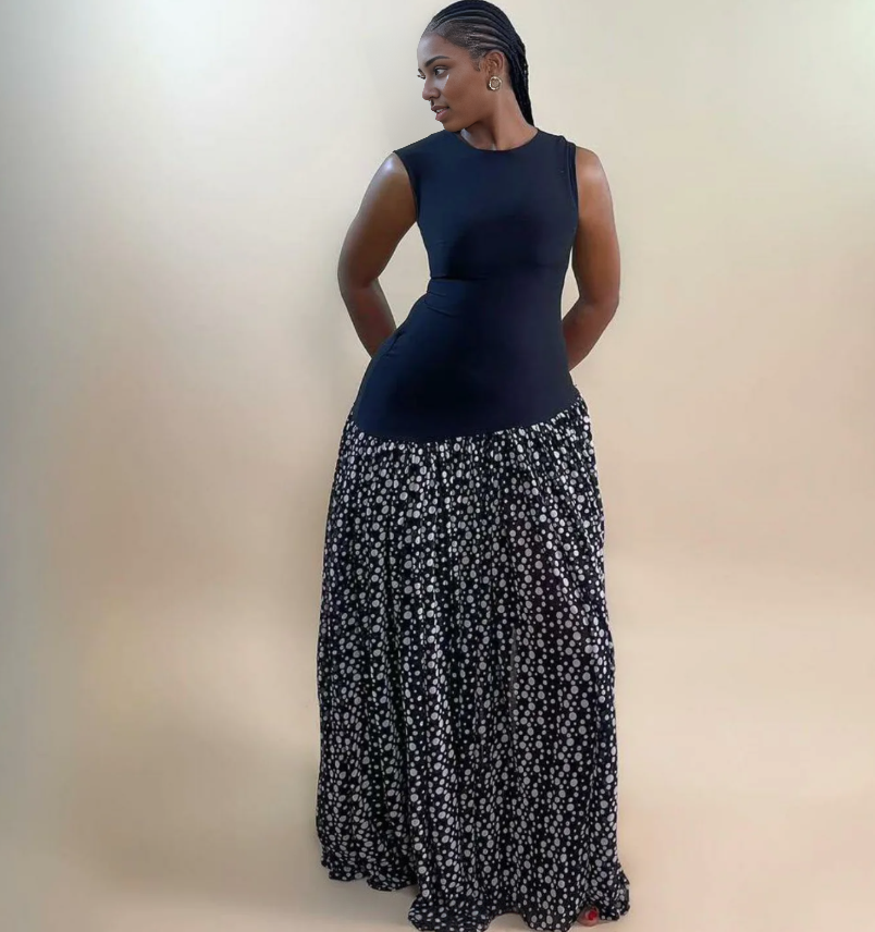 Sleeveless maxi dress with dark fitted bodice and black skirt with white floral print