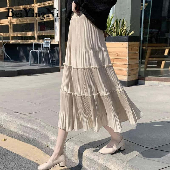 Light tan tiered pleated skirt with stretch waistband and tiered ruffle hem