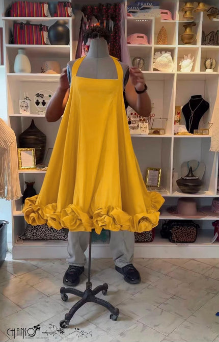 Yellow halter open-back dress with ruffled hem and full, flowy skirt
