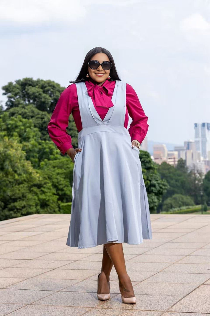 Light blue suspender midi dress with V-neck bodice and pleated skirt, front view