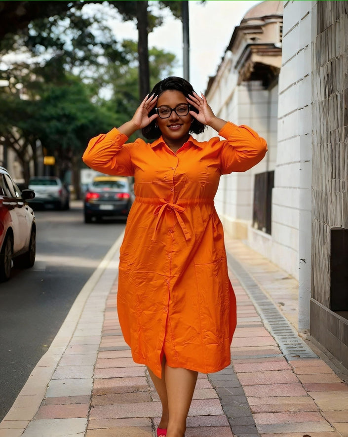 Plus size button-down dress, bright orange collared front with buttons; tied waist.