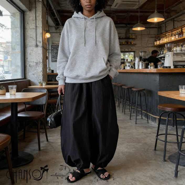 Black relaxed fit harem pants with gathered waistband and wide, draped legs