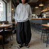 Black relaxed fit harem pants with gathered waistband and wide, draped legs