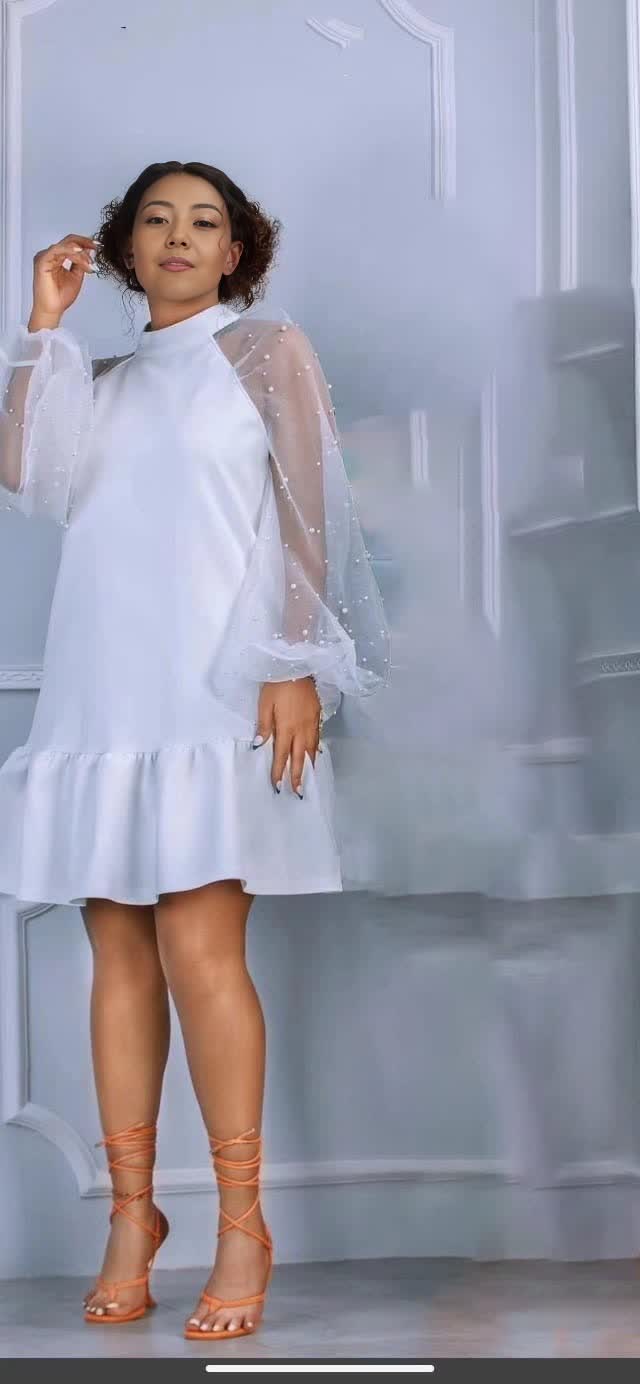 White mini dress with sheer puff sleeves and ruffle hem.