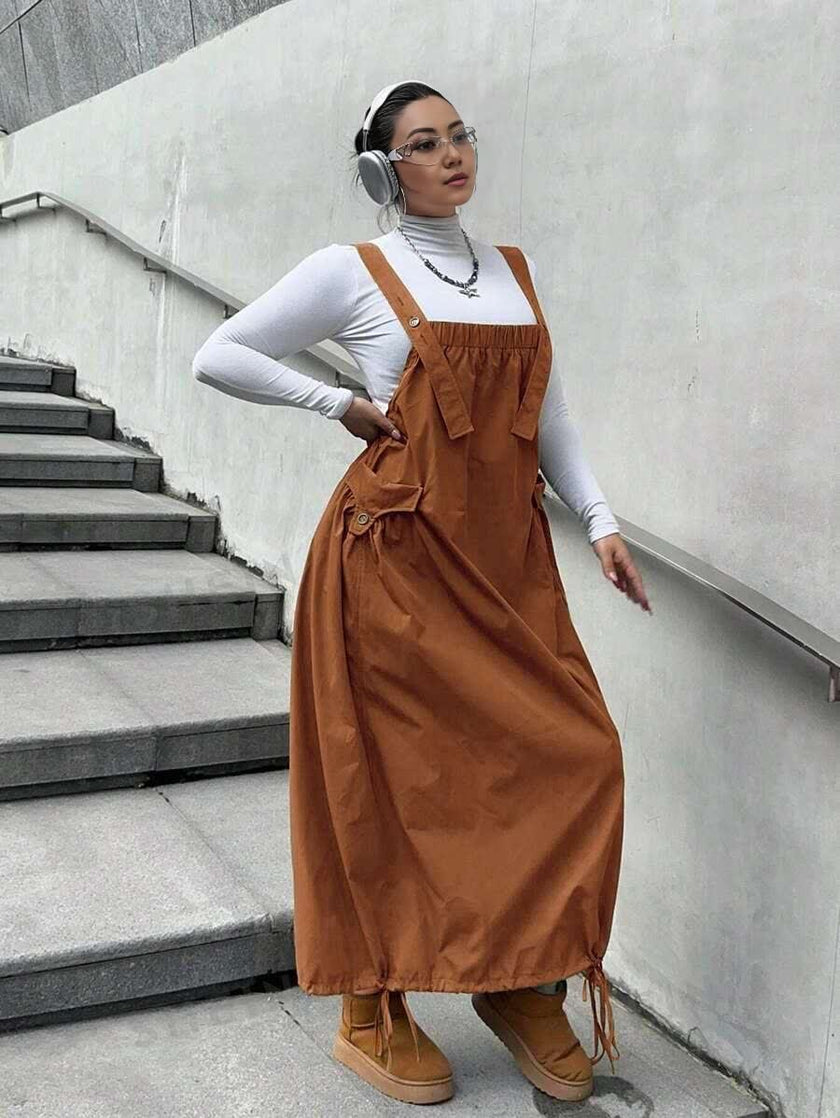 Brown workwear maxi dress with adjustable tie straps and front pocket bib