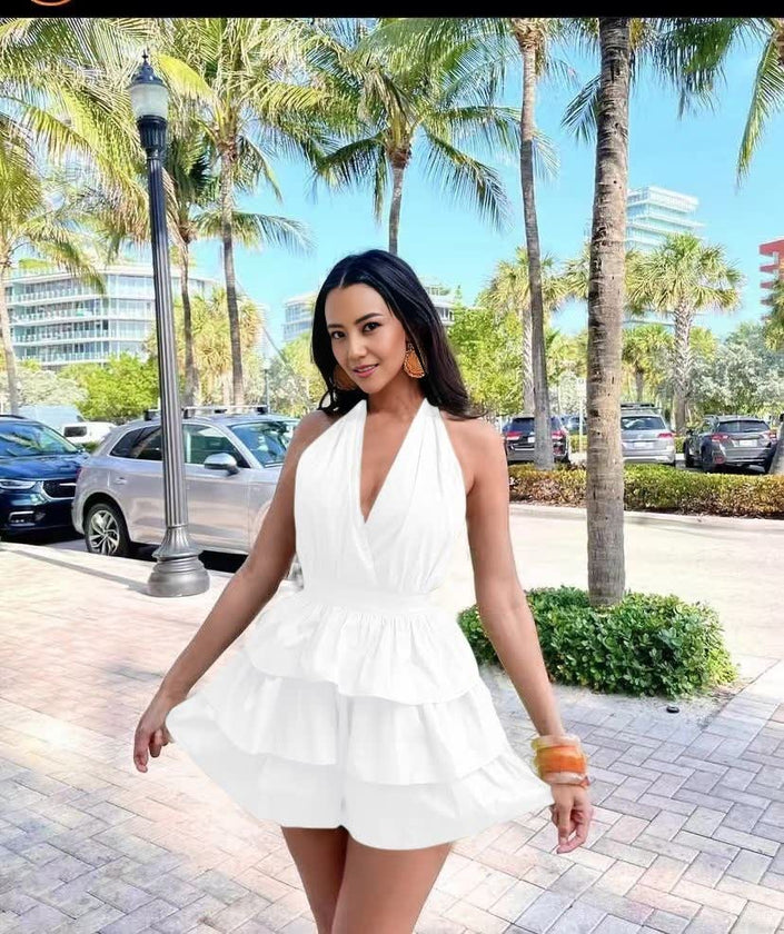 White halter layered jumpsuit with deep V neckline and tiered ruffle skirt