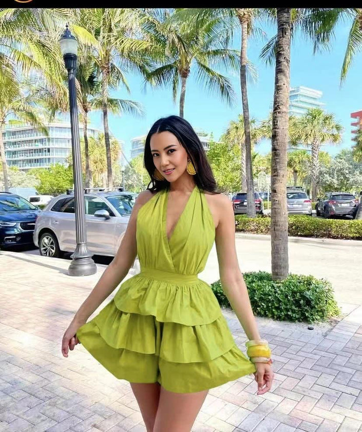 Lime green halter layered jumpsuit with deep V neckline and tiered ruffle skirt