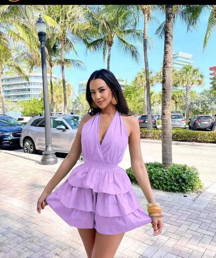 Purple halter layered jumpsuit with deep V neckline and tiered ruffle skirt