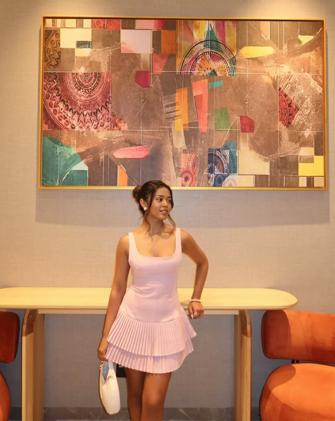 Light pink sleeveless mini dress with pleated flared skirt and scoop neckline
