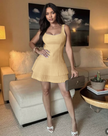 Tan sleeveless mini dress with pleated flared skirt and scoop neckline