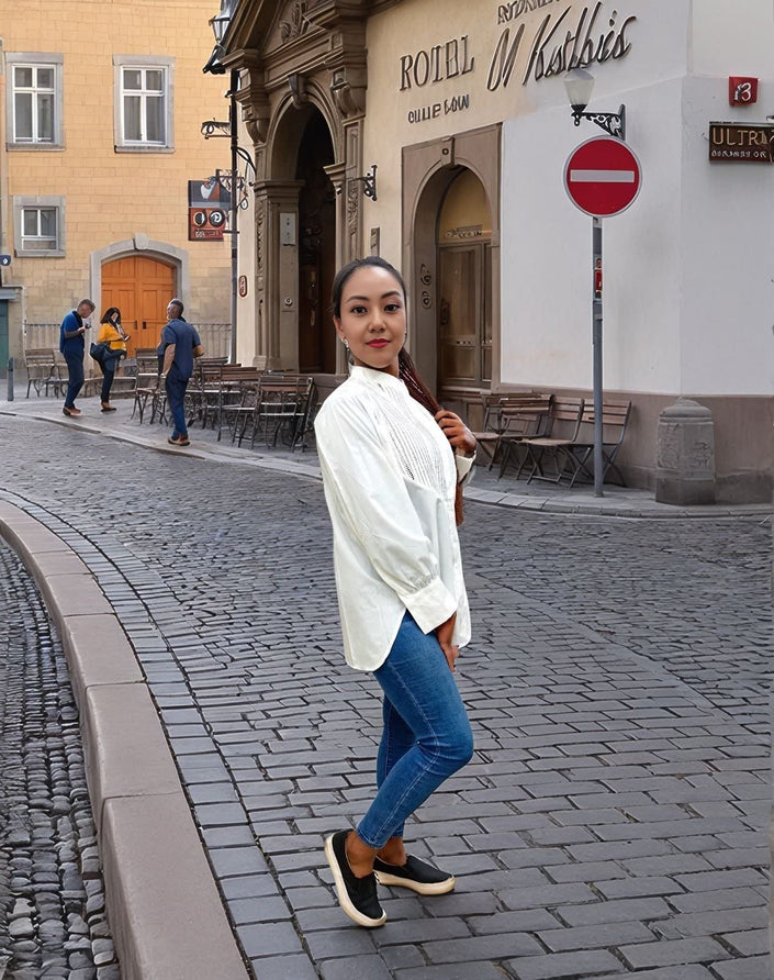 White pleated long-sleeve blouse with front opening and curved hem