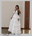 White tiered ruffle maxi dress with deep V halter straps and ruffle skirt